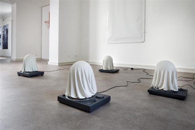 Foto von Kunstinstallation: Geistern auf Plattenspielern in ansosten leerem Raum